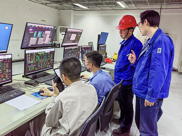 5月13日，動力車間三期鍋爐控制室，DCS改造工藝、儀表、電氣等部門聯(lián)合調(diào)試，車間主任姜軍虎與技術(shù)員畢加佳查看調(diào)試過程.jpg